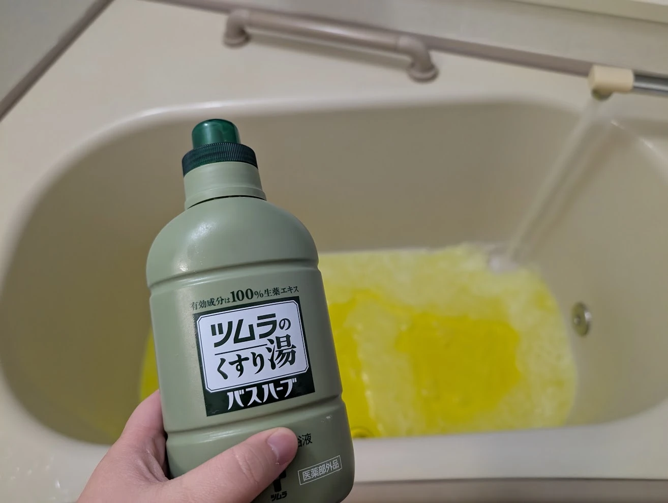 湯を張っている途中。ツムラのくすり湯で黄色に染まった湯